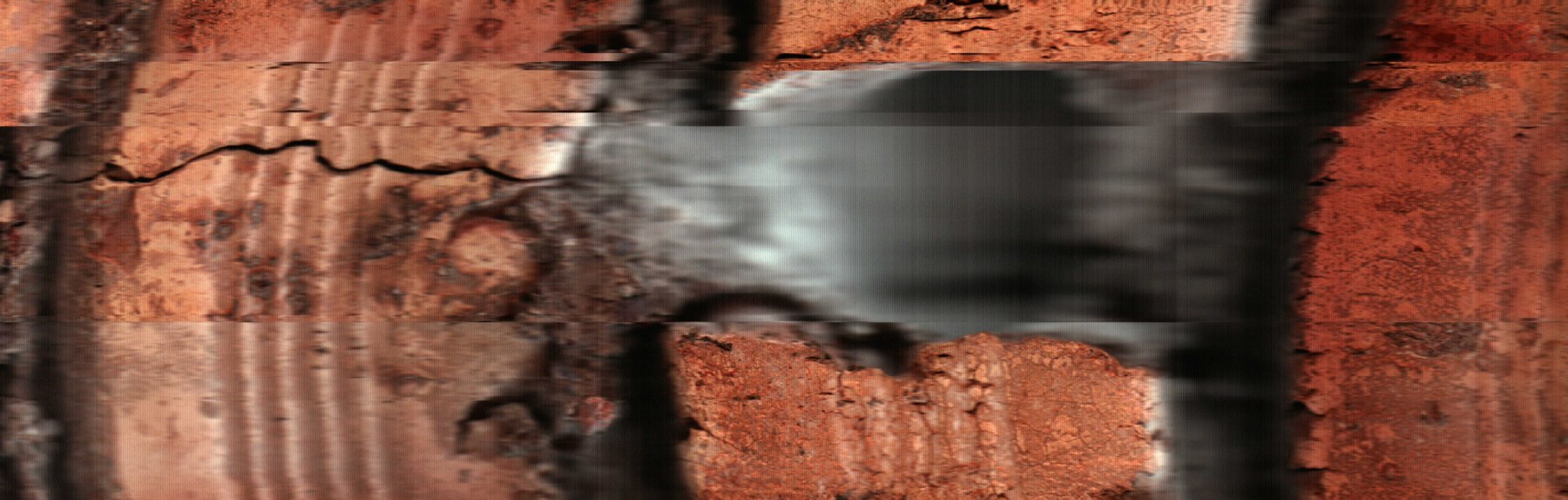 un bloque rojizo queda atravesado por una banda gris que dilata la textura.