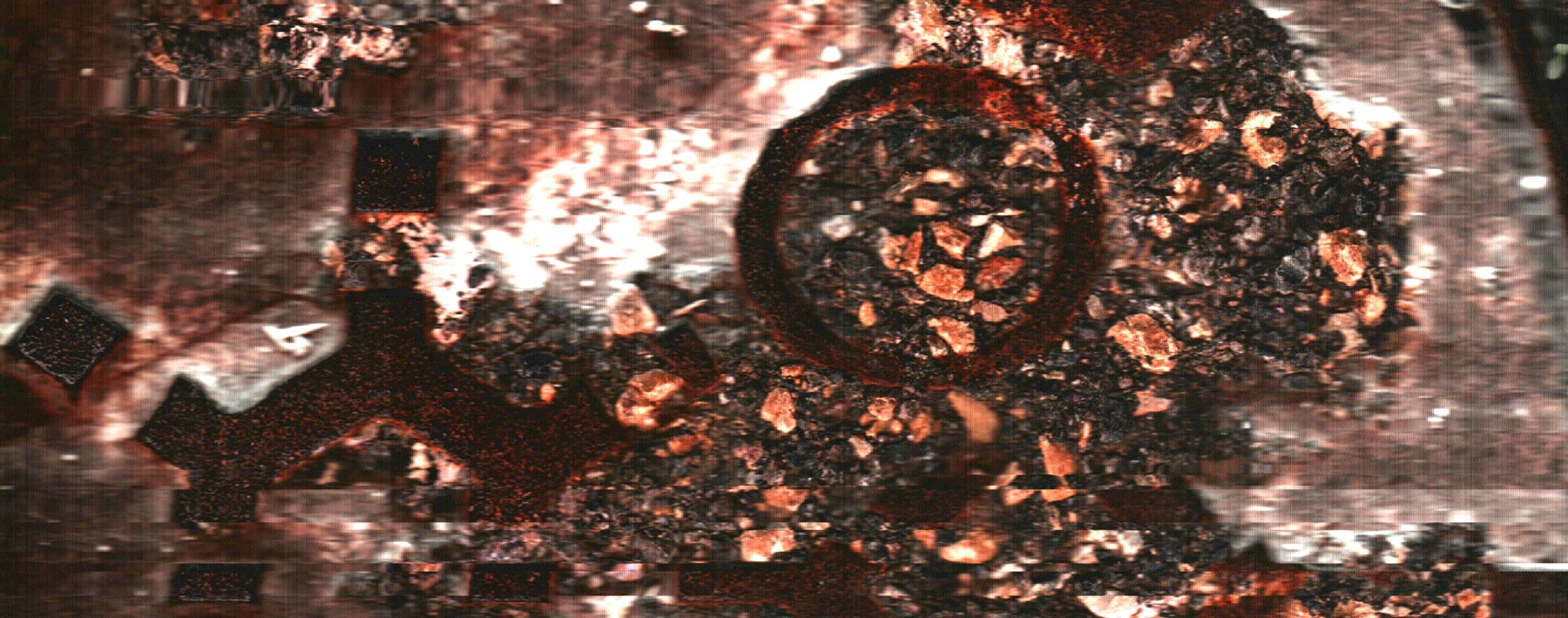 Una forma circular oscura emerge entre depósitos rojizos y zonas claras.