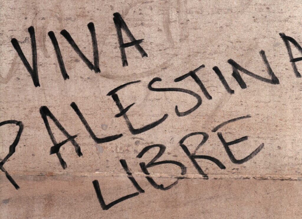 Una inscripción negra sobre fondo rosado convierte el muro en un mensaje público.