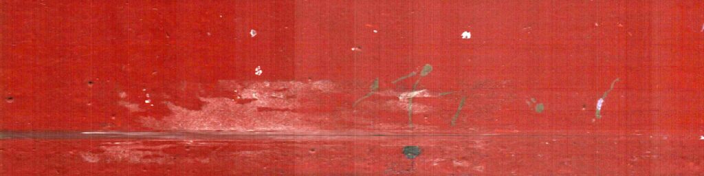 Rayas claras y pérdidas pequeñas atraviesan una superficie roja.