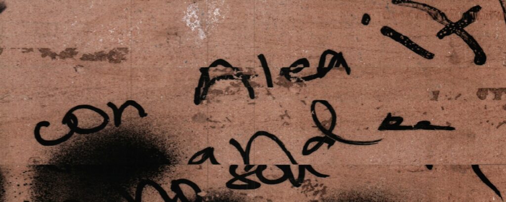 Una escritura negra recorre una base rosada y queda abierta en los bordes.